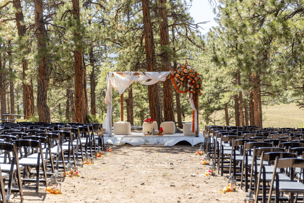 Image showing a wedding ceremony setup in a forested area, with empty chairs arranged around an altar, showcasing a beautiful outdoor venue, in line with the wedding trends for 2026 that emphasize nature-inspired, intimate celebrations.